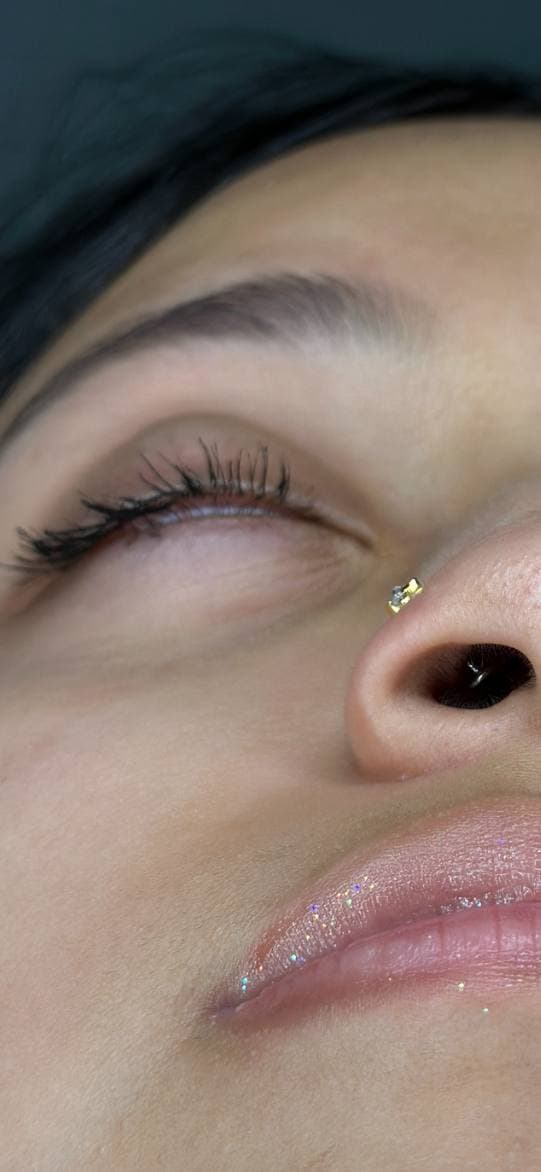 Gold nostril stud close-up after downsizing — Platinum Tattoos & Piercings San Antonio